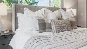A neatly made bed with a grey headboard, white and patterned pillows, and a striped blanket. - Edmonds Family Home: Walk to Yost Park, Mins to Beach & Downtown (Edmonds)