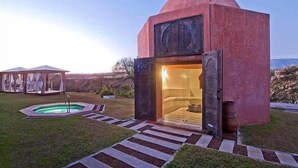A modern building with a dome-shaped roof, a swimming pool, and a covered outdoor seating area. - Asclepios Wellness & Healing Retreat (Tambor)