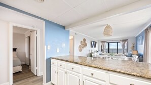 Eine moderne Küche mit weißen Schränken, Granit Arbeitsplatten und einem Essbereich mit weißem Tisch und Stühlen.