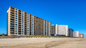 Ein mehrgeschossiges Hotel mit einheitlicher Fassade in Strandnähe.