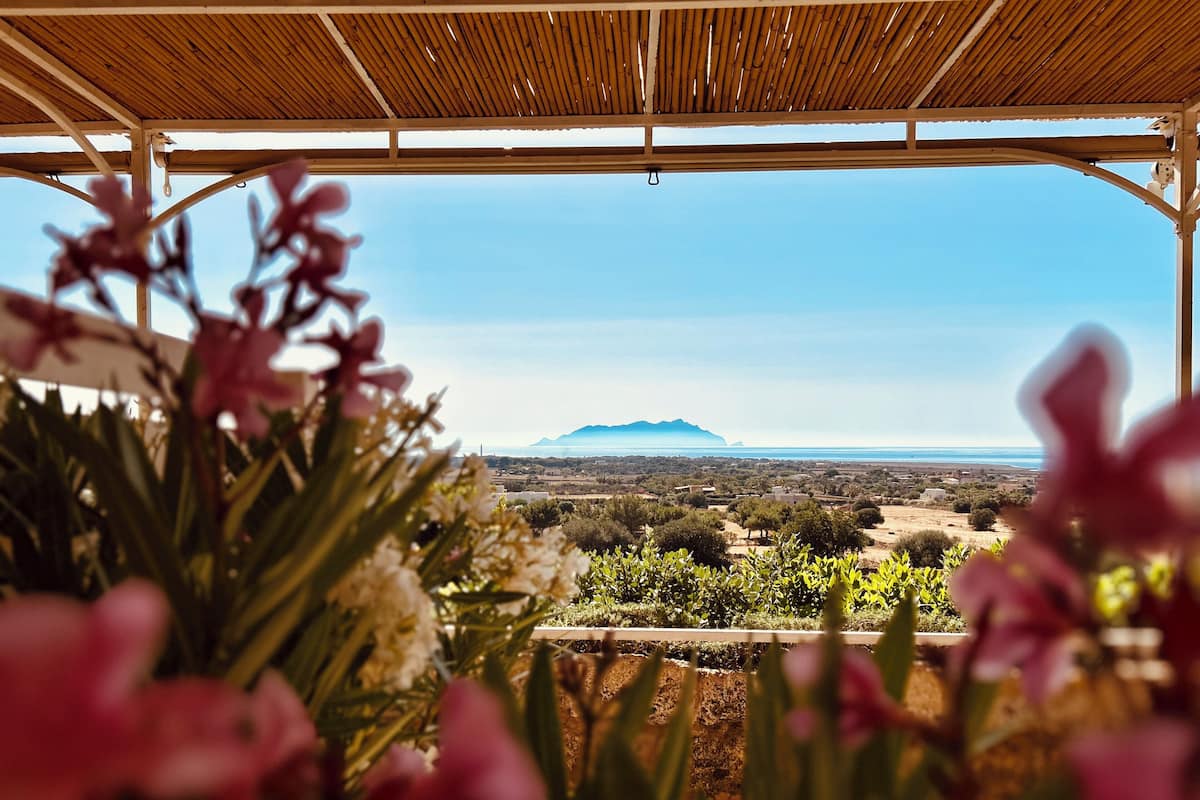 Un'area esterna riparata con vista su un paesaggio lontano, che include una montagna e un corso d'acqua.