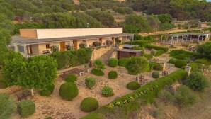 A modern building with a long corridor and multiple rooms, surrounded by well-maintained gardens and trees. - Alencio Panorama Residence (Favignana)