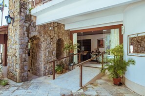 Arc de pedra que condueix a una habitació amb un llit i una finestra.