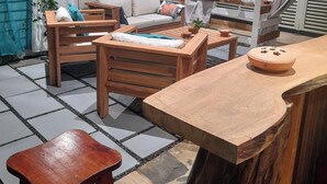 Un espacio al aire libre acogedor con mobiliario de madera, un sofá blanco y una decoración con forma de corazón.