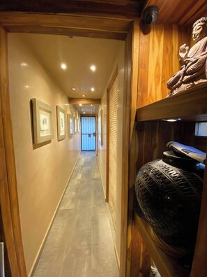 Stunning hallway with framed artwork and a large window at the end.
