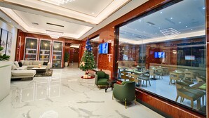 A modern lobby with a Christmas tree, seating area, and a large glass wall. - Blu Atlantic Hotel (Lekki)