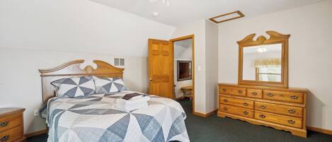 Un dormitorio con cama, cómoda y ventilador de techo.