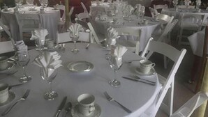 A dining area with round tables set for service, white tablecloths, and chairs. - Vermilion Park Inn, #7 Spanish Room (Soudan)