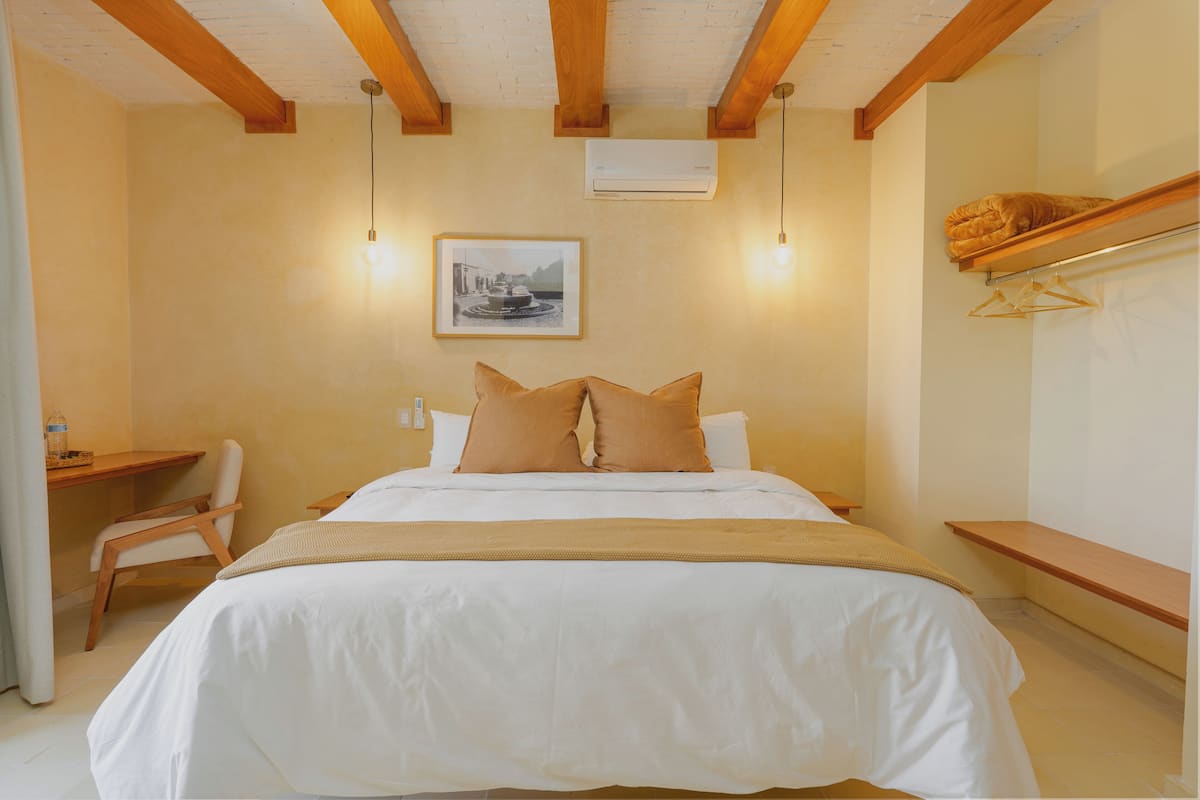 A hotel room with a bed, a desk, and a chair.
