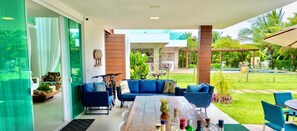 Relax in a serene outdoor space with a seating area, dining table, and unobstructed views of the lush garden and pool.