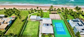 Guests can enjoy a tranquil stay in our bungalow-style accommodations, surrounded by a lush green space and a tennis court, with access to the beach.