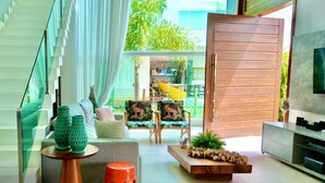 Un interior moderno con una escalera, un sofá, una mesa de centro y un televisor.