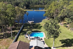 A residential area with a swimming pool, a dock, and a lake.