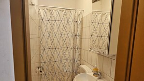 Ein Badezimmer mit Toilette, Waschbecken und Duschvorhang.