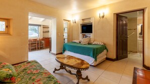 A bedroom with a bed, a TV, a table, and a chair. - Apartment 'Le Repaire' with Mountain View, Shared Terrace and Garden (Cassis)