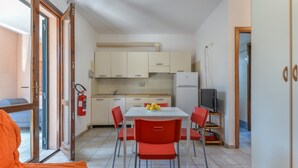 Una cocina compacta con una mesa de comedor, sillas y un televisor.