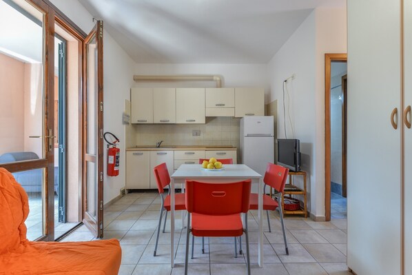 Una cocina compacta con una mesa de comedor, sillas y un televisor.