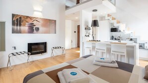 A modern hotel room with a fireplace, a dining area, and a kitchen. - Apartment 'Melo' with Balcony, Wi-Fi and Air Conditioning (Palermo)