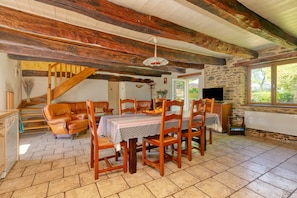 A dining area with a wooden table, chairs, and a staircase.