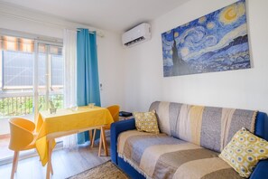 A living room with a sofa, a table, and a painting on the wall.