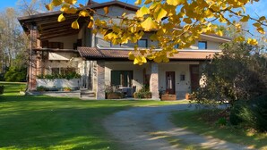 A two-story house with a covered porch, a brick chimney, and a well-maintained lawn. - Holiday Home 'Alpi Liguri' with Mountain View, Shared Terrace and Wi-Fi (Peveragno)