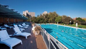 A swimming pool with sun loungers and a covered deck area. - Pret-A-Porter (Prahran)