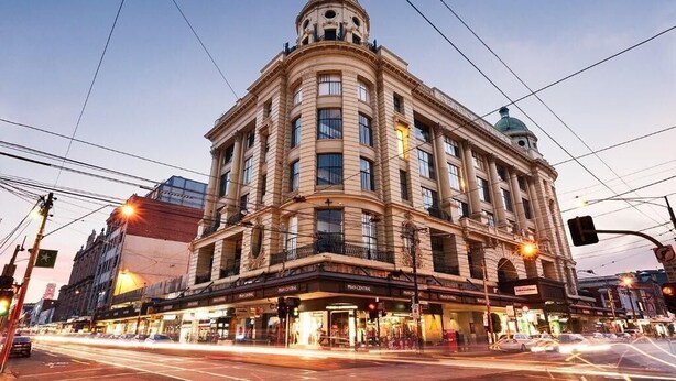 A historic building with a central dome and multiple floors, featuring a prominent entrance with signage. - Pret-A-Porter (Prahran)