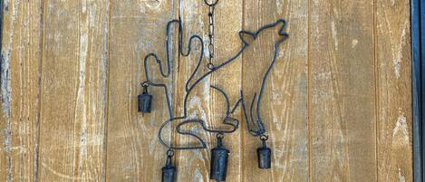 A wooden door with a metal decorative piece featuring a bird and leaves.