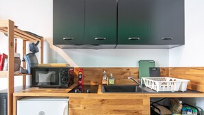 A compact kitchen with a microwave, toaster, sink, and wooden cabinets. - Beautiful renovated studio, balcony, 4pers (Chamrousse)