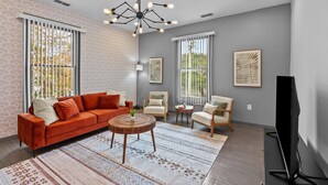 A modern living room with a sofa, chairs, a coffee table, and artwork on the walls.