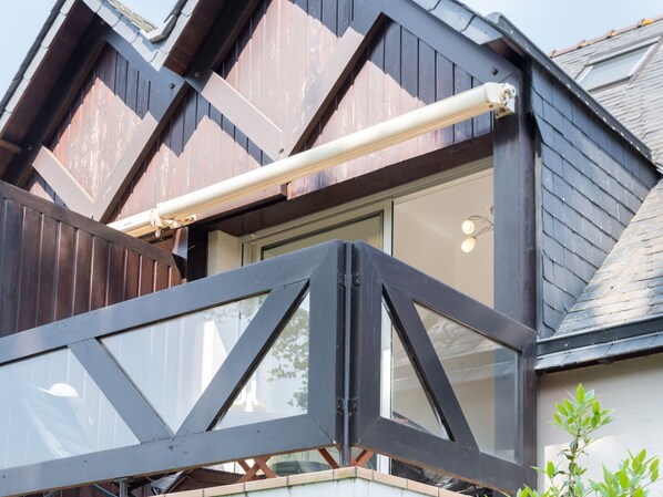 A modern building with a prominent black metal structure and a large window.