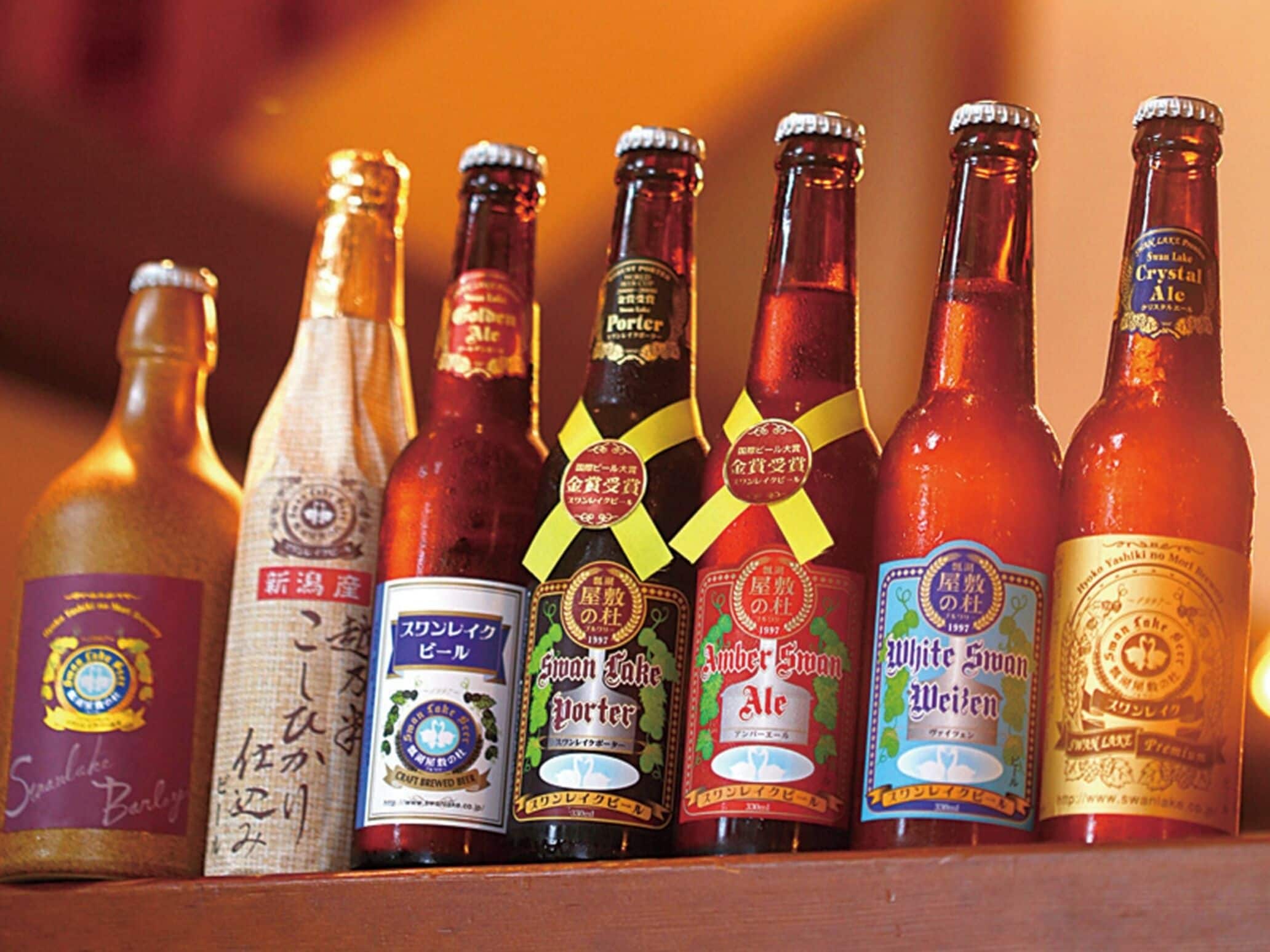 A row of beer bottles with labels, some featuring text and logos.