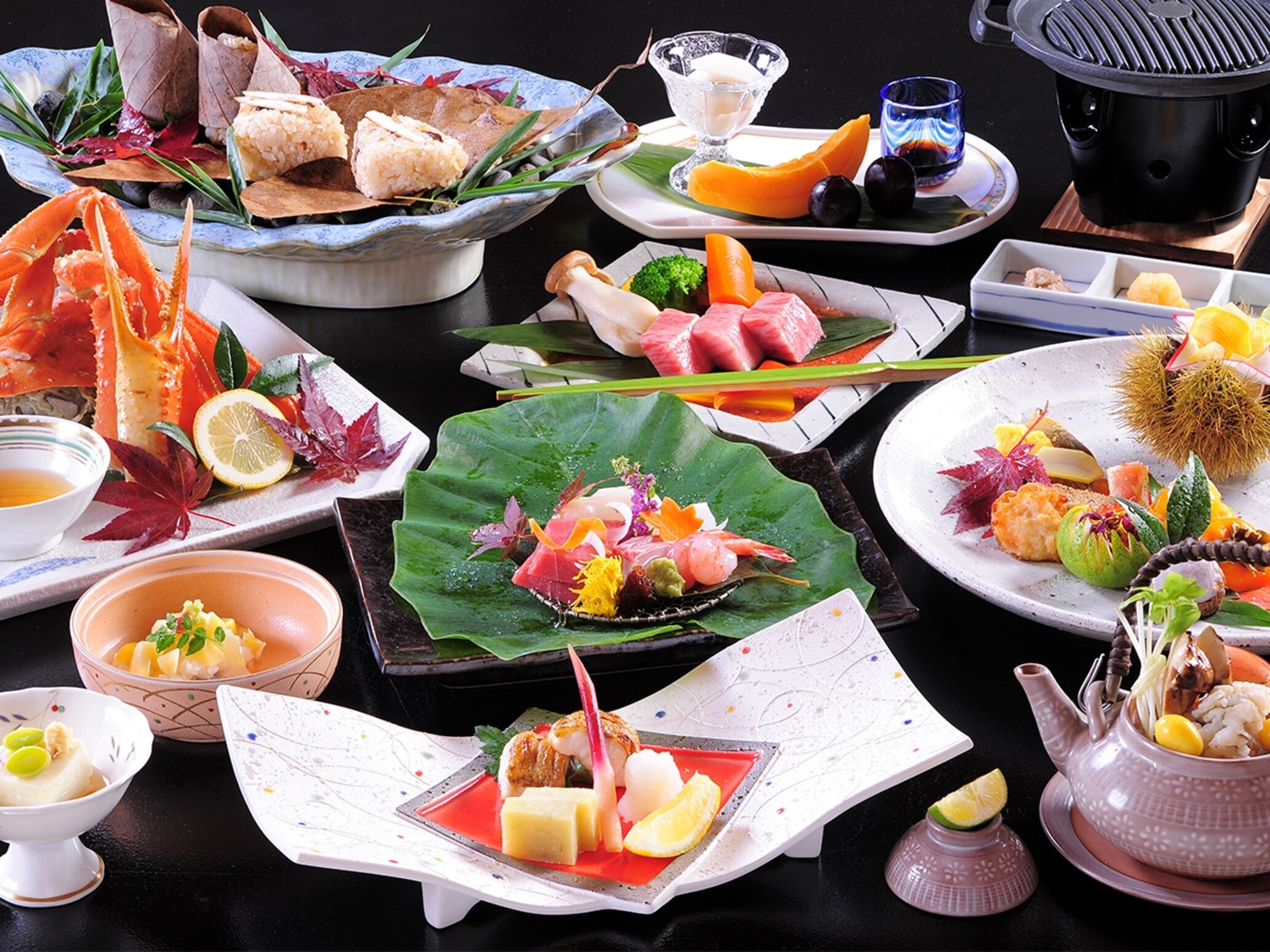 A variety of dishes on a table, including seafood, vegetables, and a teapot.