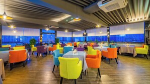 A spacious restaurant with high ceilings, modern lighting, and large windows offering city views. - HOWDY SMART HOTEL (Chengdu)