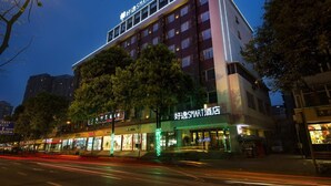 A multi-story hotel with a prominent sign reading "好逸SMART酒店" and a well-lit entrance. - HOWDY SMART HOTEL (Chengdu)