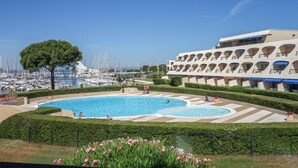 Ein Schwimmbad mit Blick auf einen Yachthafen und ein Gebäude mit Balkonen.