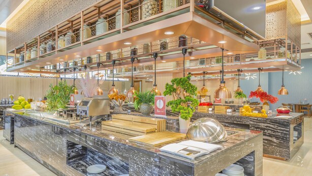 A modern hotel lobby with a marble reception desk, multiple dining areas, and a decorative ceiling with hanging lights. - Lidu International Hotel (Handan)