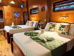 A hotel room with two beds, wooden walls, a globe, and a decorative wall piece.