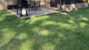 A house with a brick exterior, a covered patio with a grill, and a fenced backyard. - Surfside Hideaway! Dog friendly 3 bed, 2 bath home. Only 1 mile to beach! (Myrtle Beach)