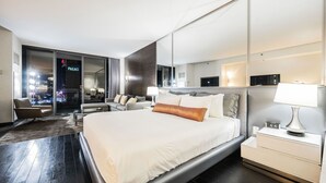 A modern hotel room with a large bed, a sofa, a desk, and a view of the cityscape. - SVS: Strip View Studio | Open Balcony | Pool Access | Palms Place (Las Vegas)