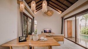 Un comedor amplio con una mesa de madera, sillas tejidas y un ventanal que ofrece vistas al exterior.