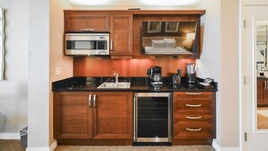 A compact kitchen with a microwave, coffee maker, and dishwasher. - SVS: Strip View Studio | Pool & Gym Included | No Resort Fee | MGM (Las Vegas)