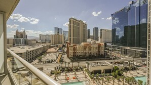 A high-rise hotel with a rooftop pool, surrounded by modern buildings and a clear sky. - SVS: Strip View Studio | Private Balcony | Pool & Gym | Signature at MGM (Las Vegas)