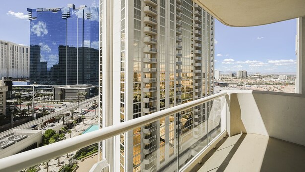 A high-rise building with multiple balconies, a clear view of the surrounding cityscape, and a pool area visible in the foreground. - SVS: Strip View Studio | Private Balcony | Pool & Gym | Signature at MGM (Las Vegas)