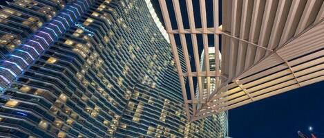 A high-rise hotel with a modern design, featuring a distinctive sloped facade and a large, open-air structure with a grid-like pattern.
