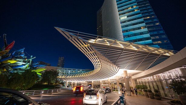 Um edifício moderno com telhado curvo e fachada de vidro.