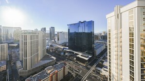 Stadsbeeld met moderne hoge gebouwen, een opvallend glazen gebouw en een heldere lucht.