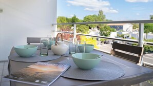 A balcony table with a magazine, bowls, glasses, and a teapot. - Arcachon Marines by Interhome (Arcachon)