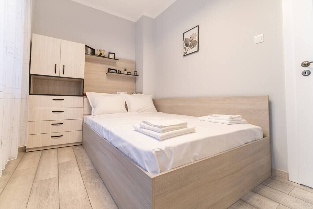 Une chambre avec un lit en bois, une armoire intégrée et une étagère de chevet.