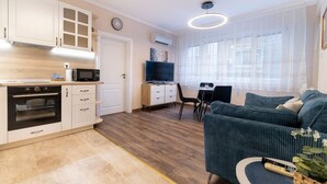 A compact living space with a kitchenette, a dining area, and a seating area with a sofa.